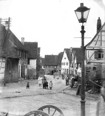 Die mit Straßenbeleuchtung und "Kandeln" (Rinnsteinen) versehene Hauptstraße um 1925.